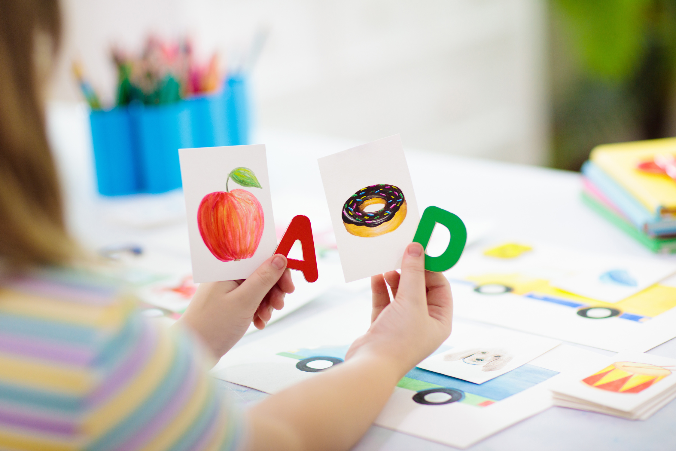 A child holding up letter cards during a phonics lesson